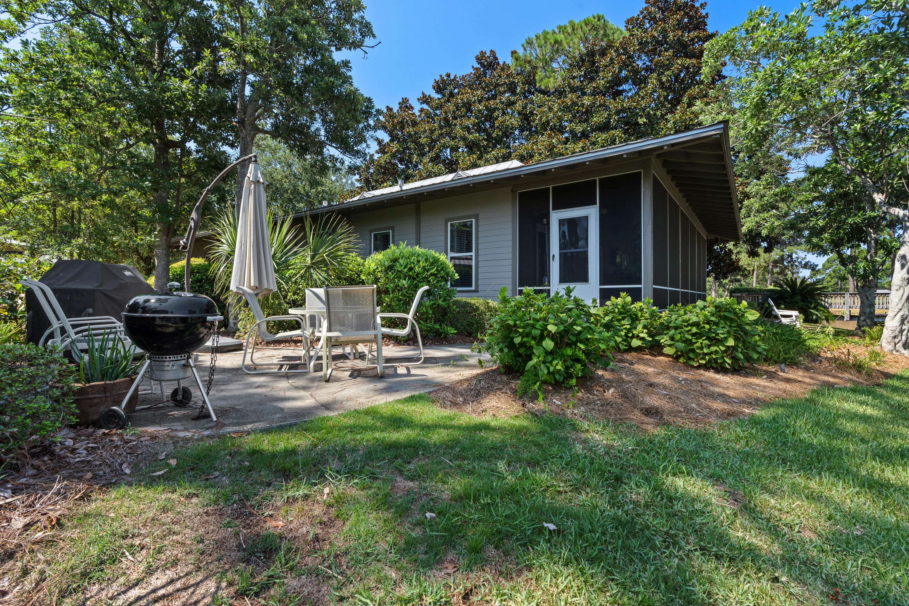 1108 Prestwick Place Miramar Beach, FL 32550 - Photo 42 of 47 a view of a house with backyard sitting area and a garden