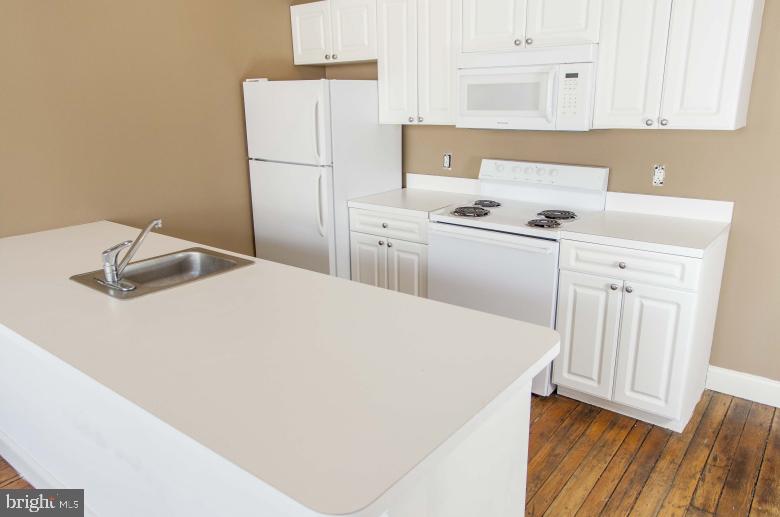 1222-26 Arch Street, Unit 507 Philadelphia, PA 19107 - Photo 2 of 22 a kitchen with a refrigerator a sink and cabinets