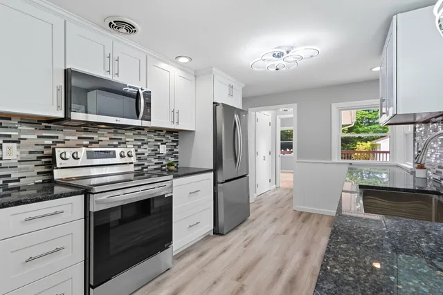 a kitchen with stainless steel appliances a stove microwave and refrigerator