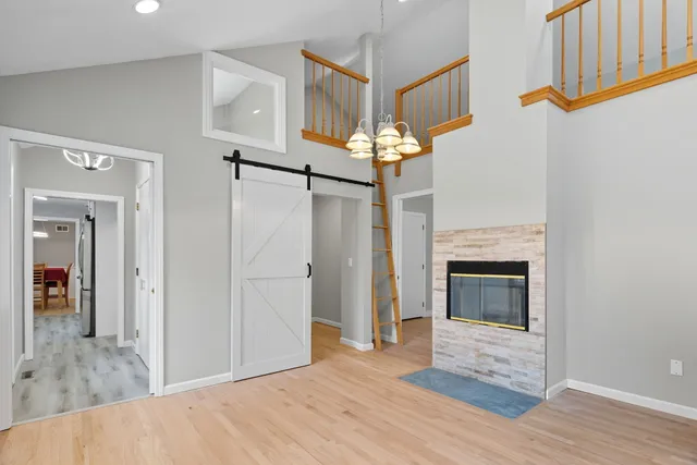 a view of a livingroom with wooden floor and kitchen view