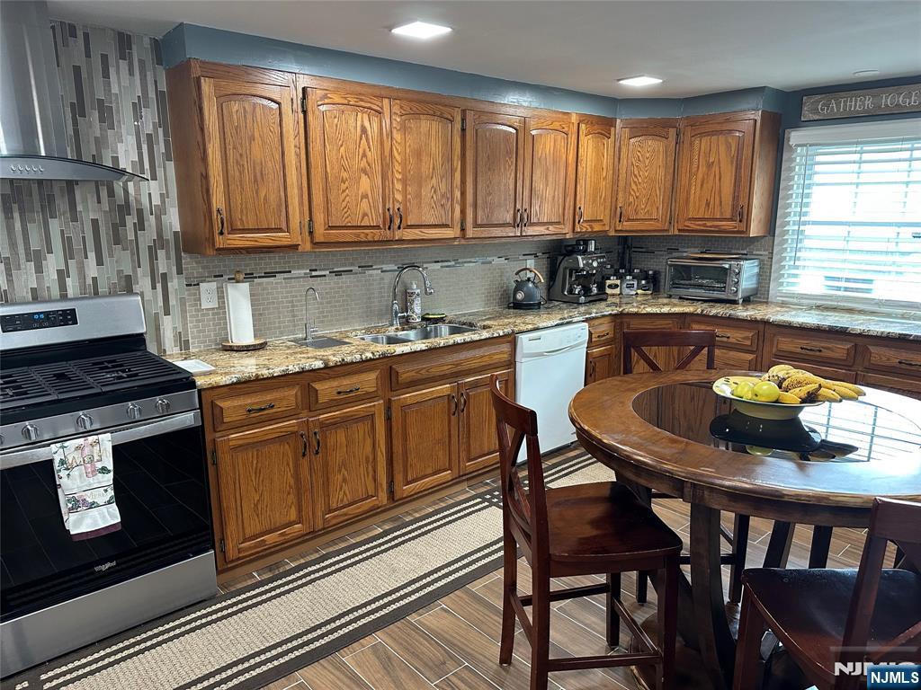 15 2nd Street Lodi, NJ 07644 - Photo 10 of 32 a kitchen with a stove a sink and chairs