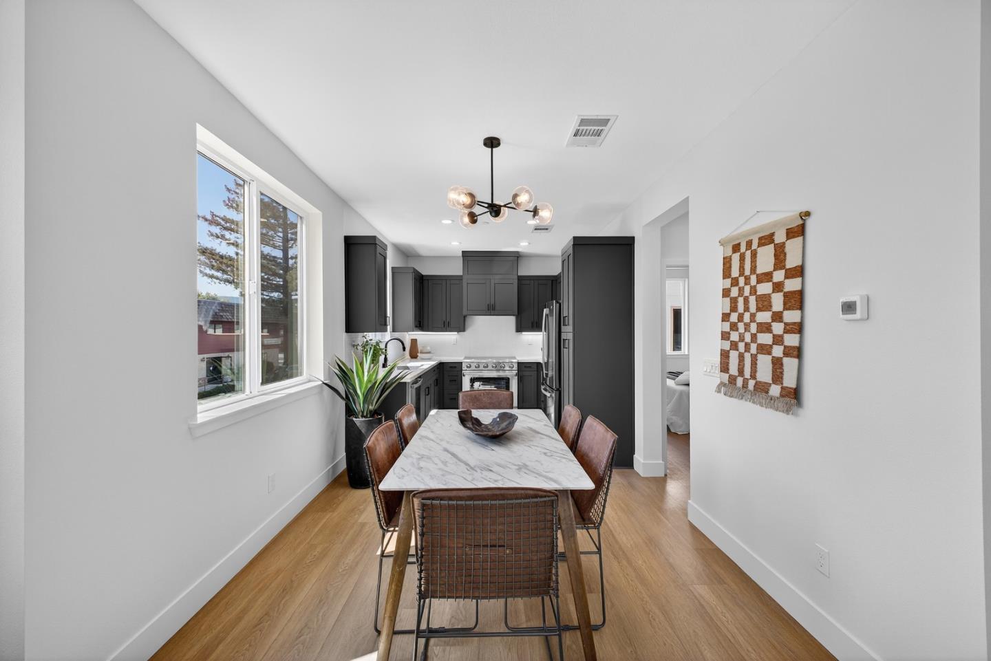 955 Woodside Road Redwood City, CA 94061 - Photo 18 of 46 a view of a dining room with furniture wooden floor and chandelier