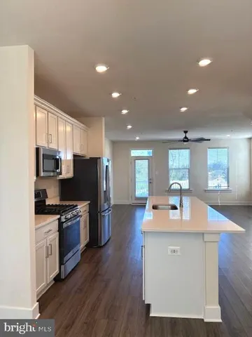 a kitchen with stainless steel appliances granite countertop a sink refrigerator and microwave