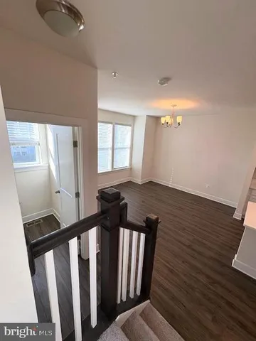 a view of a hallway with wooden floor and entryway