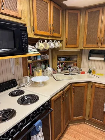 a kitchen with a sink a stove and cabinets