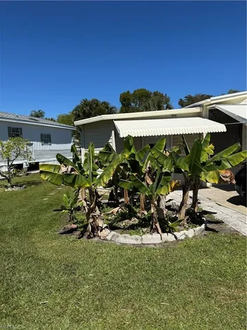 a view of a house with a yard and sitting area