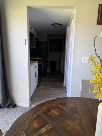 a view of a hallway to room with wooden floor and staircase