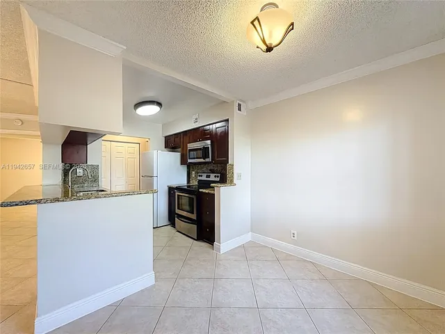 a kitchen with granite countertop a refrigerator and a sink