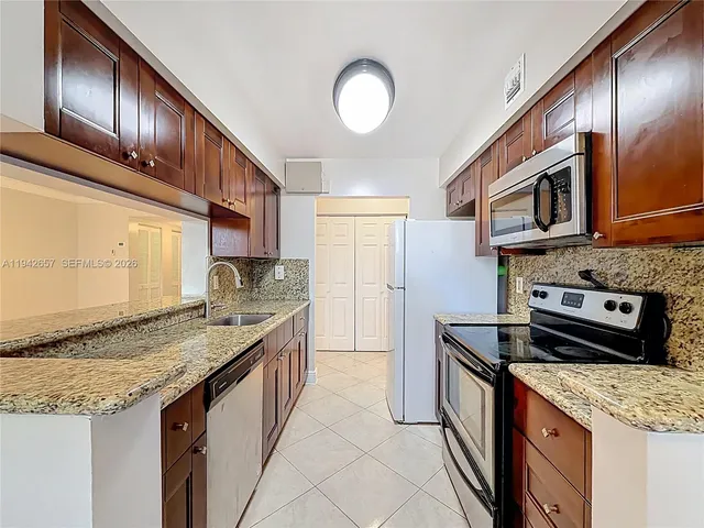 a kitchen with stainless steel appliances granite countertop a stove microwave and refrigerator