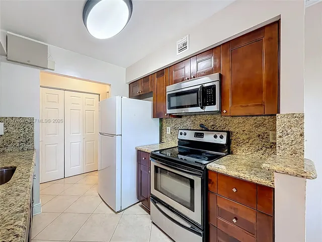 a kitchen with granite countertop stainless steel appliances and wooden cabinets