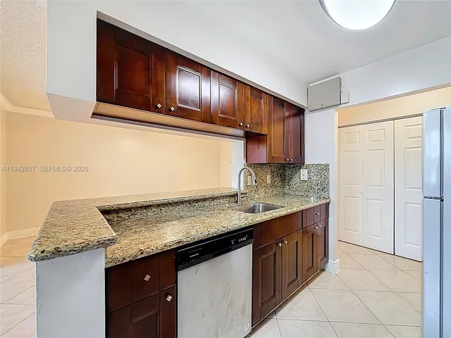 a kitchen with granite countertop stainless steel appliances wooden cabinets and a sink
