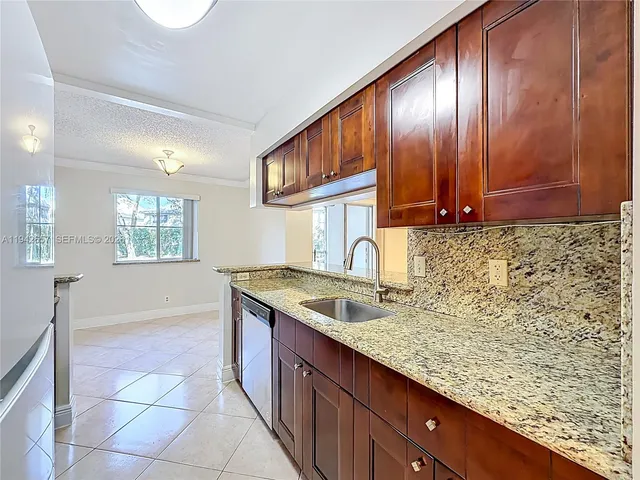 a kitchen with granite countertop a sink and a stove top oven