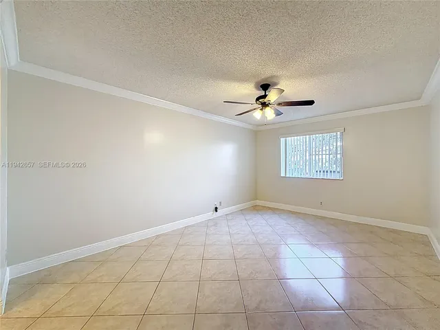 a view of an empty room with a chandelier fan