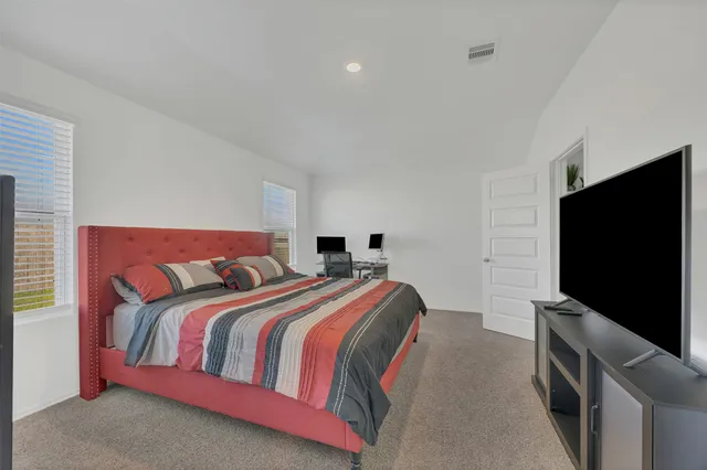 a bedroom with a bed and a flat screen tv