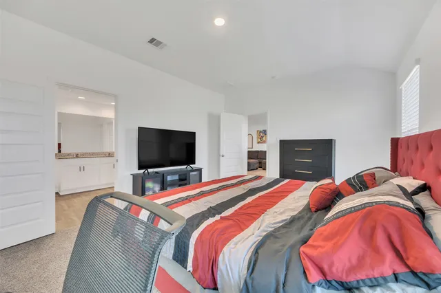 a bedroom with a bed and a flat screen tv