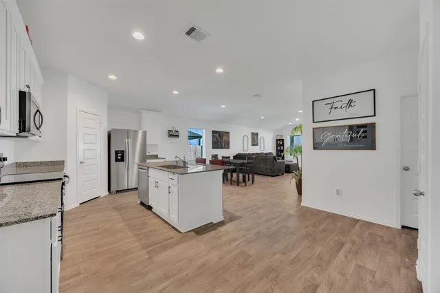 a view of a kitchen with furniture and refrigerator