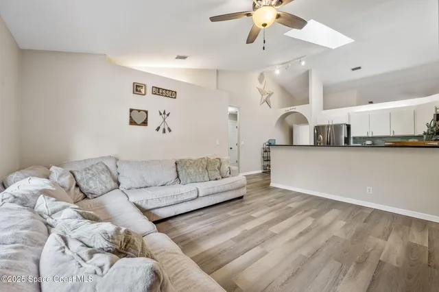 a living room with furniture and kitchen view