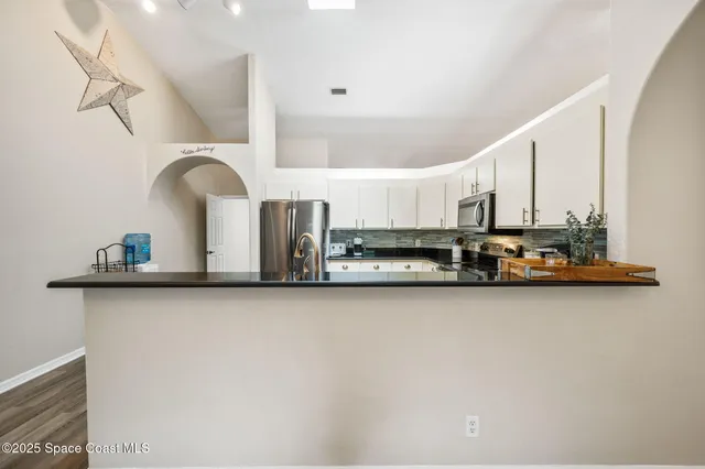 a kitchen with stainless steel appliances a sink a stove and cabinets