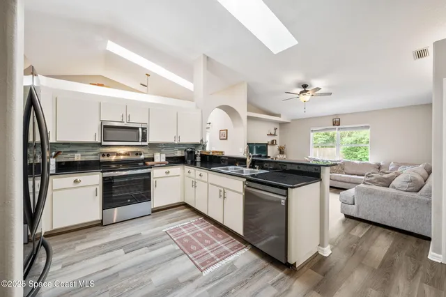 a kitchen with granite countertop a stove top oven and cabinets