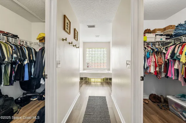 a view of walk in closet with clothes and shoes