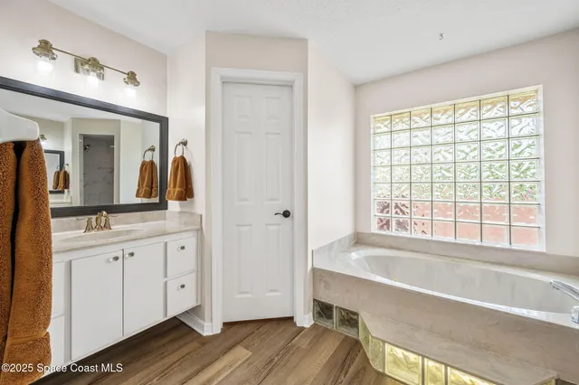 a bathroom with a tub sink and mirror