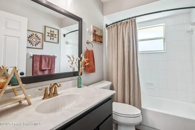 a bathroom with a granite countertop sink a toilet and a tub