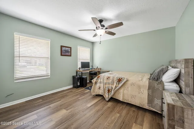 a bedroom with a bed and wooden floor