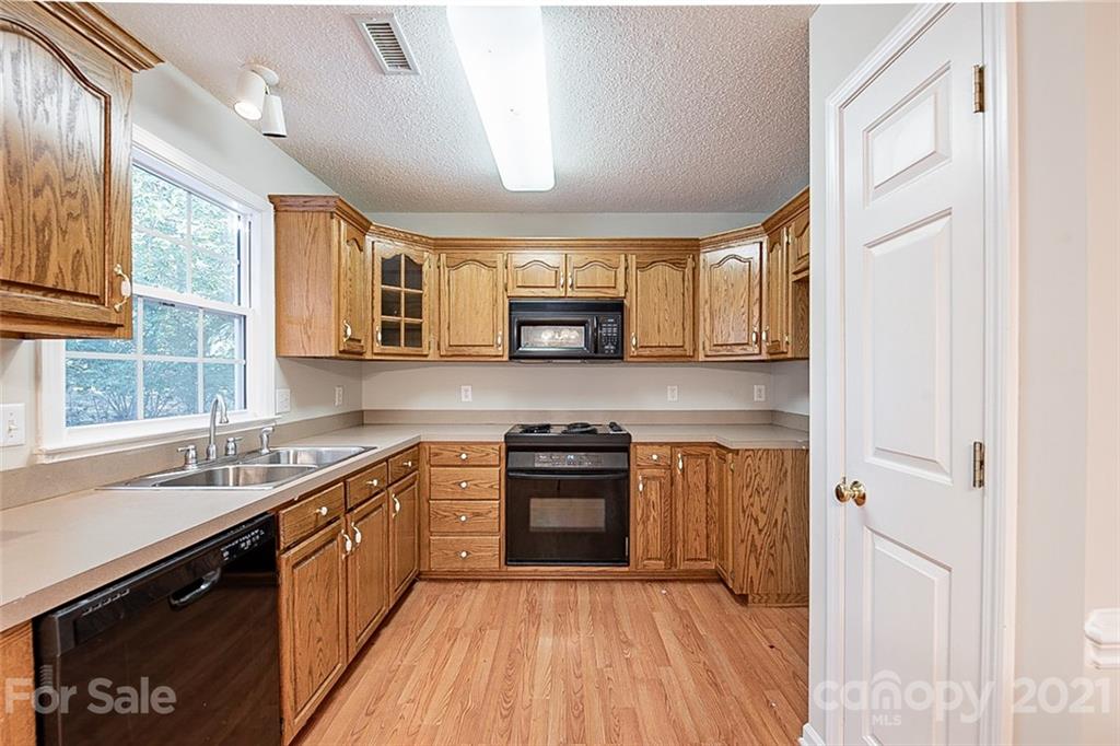 1323 Tucker Road Monroe, NC 28110 - Photo 4 of 17 a kitchen with a sink a stove and cabinets