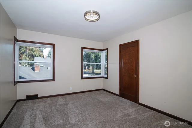 an empty room with windows and closet