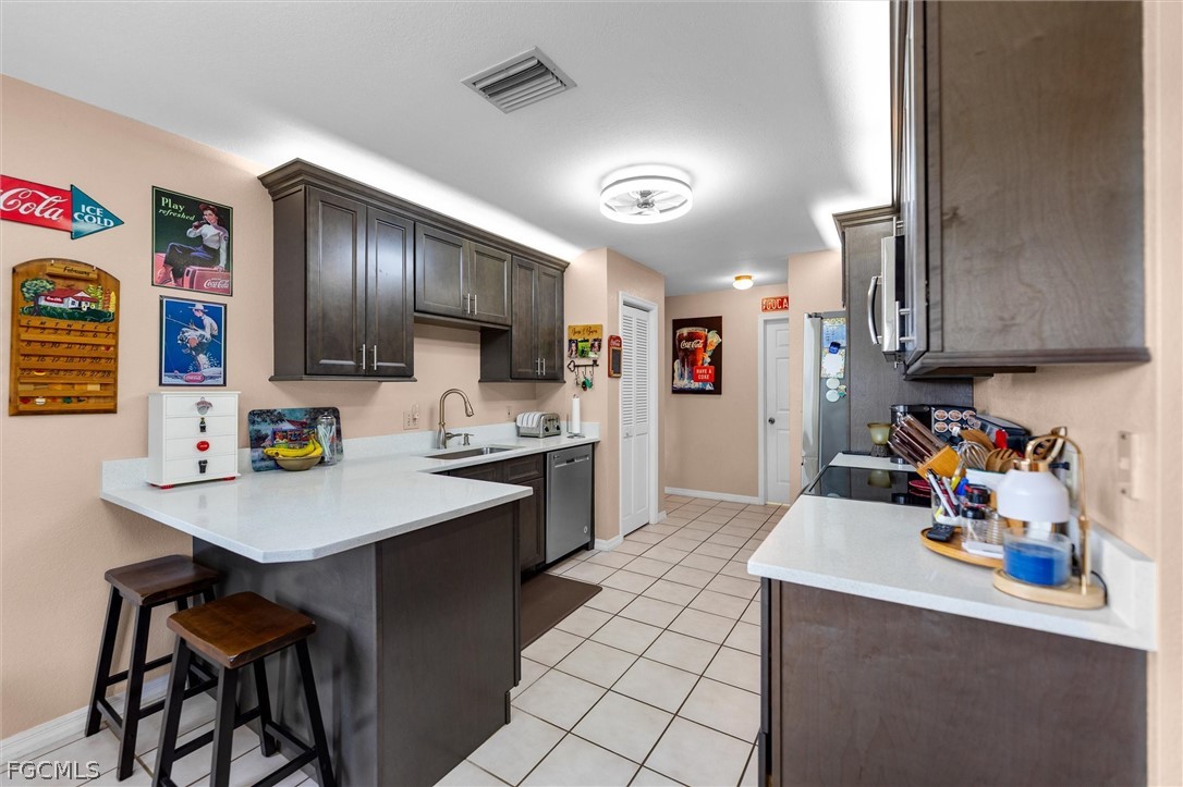 5997 Dragoon Court Fort Denaud, FL 33935 - Photo 18 of 49 a kitchen with a sink a stove and chairs