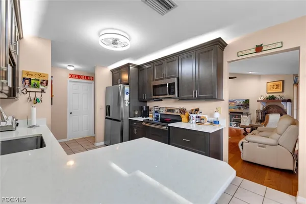 a kitchen with a refrigerator a stove top oven a sink dishwasher and white cabinets with wooden floor