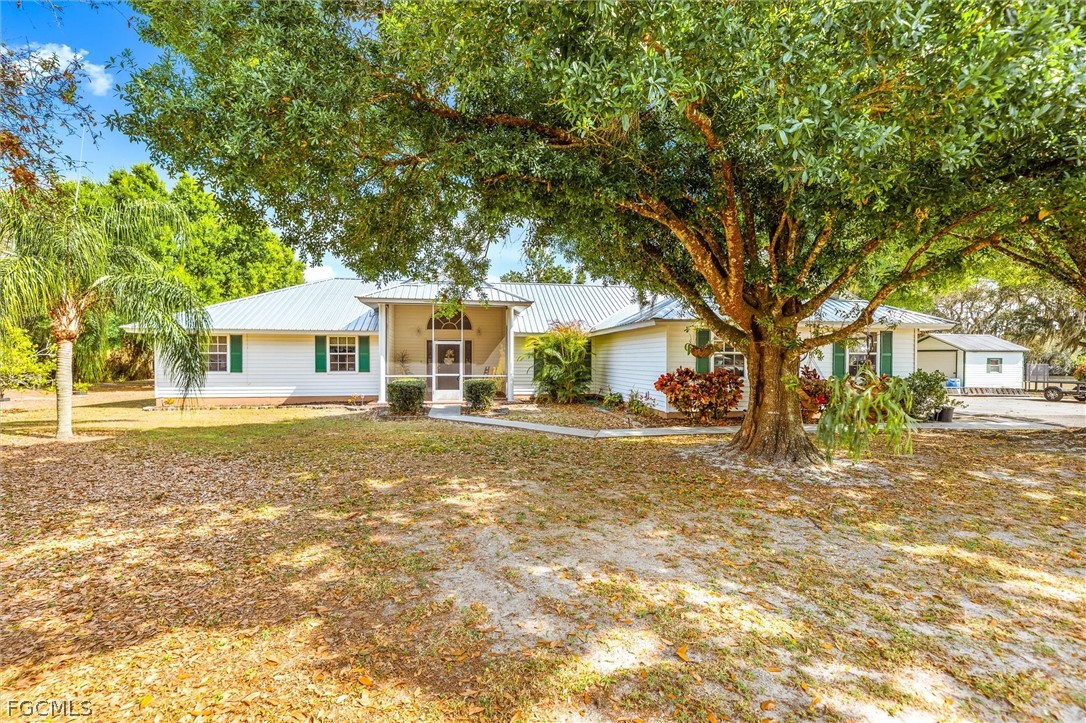 5997 Dragoon Court Fort Denaud, FL 33935 - Photo 2 of 49 a view of a house with a yard and large tree
