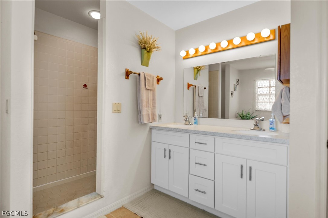 5997 Dragoon Court Fort Denaud, FL 33935 - Photo 24 of 49 a spacious bathroom with a granite countertop sink a mirror and a shower