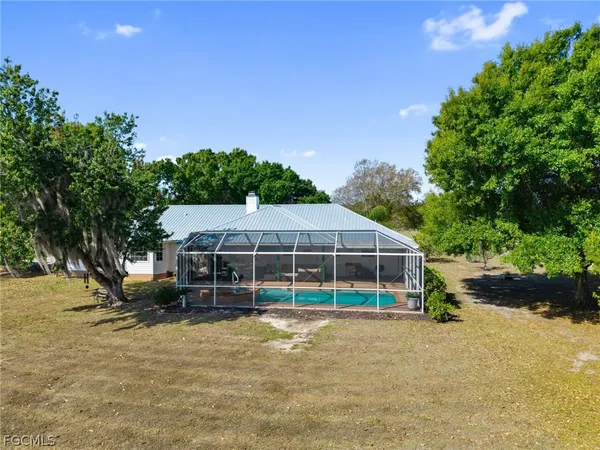a view of a house with a backyard and a tree