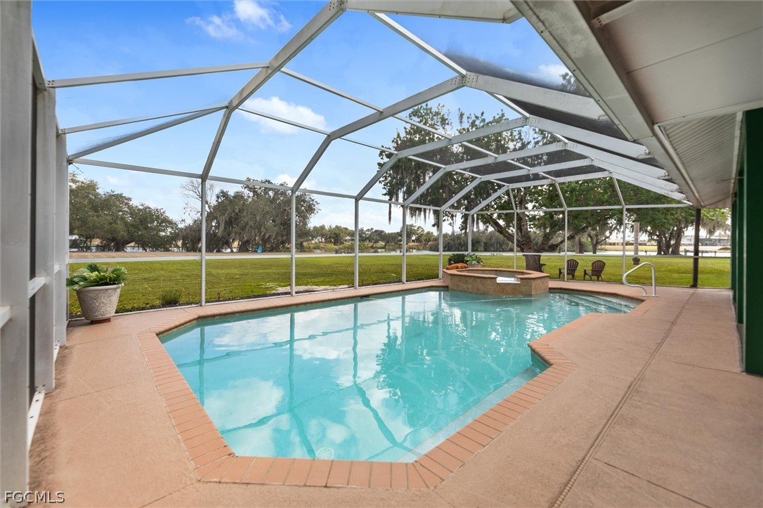 5997 Dragoon Court Fort Denaud, FL 33935 - Photo 9 of 49 a view of a swimming pool with a porch in front of it
