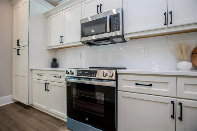a view of a kitchen with stainless steel appliances granite countertop a stove and a refrigerator
