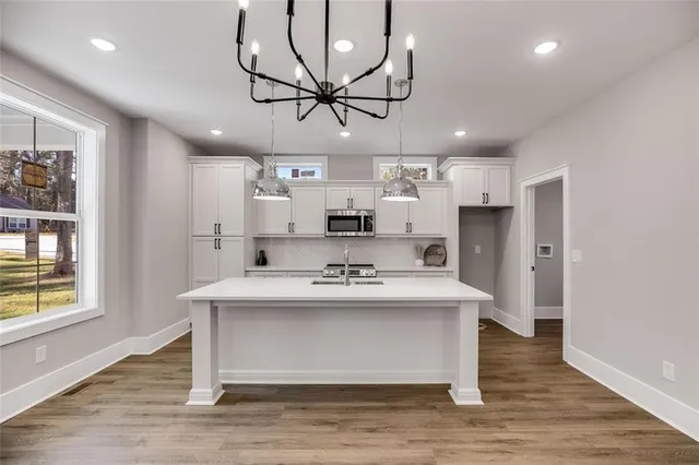 a kitchen that has a sink and a stove top oven