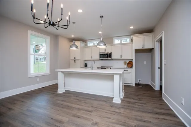 a view of kitchen with granite countertop stainless steel appliances cabinets a sink and a window