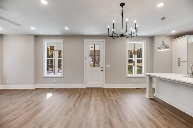 a view of an empty room with window and wooden floor