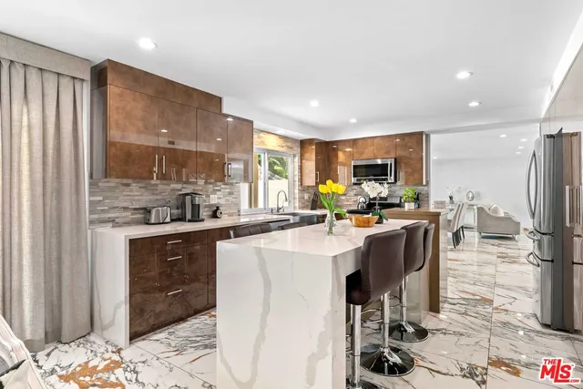 a kitchen with sink refrigerator dining table and chairs