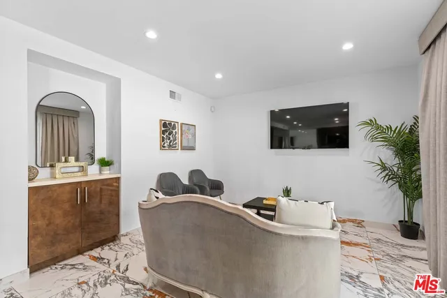 a living room with furniture and a painting on the wall
