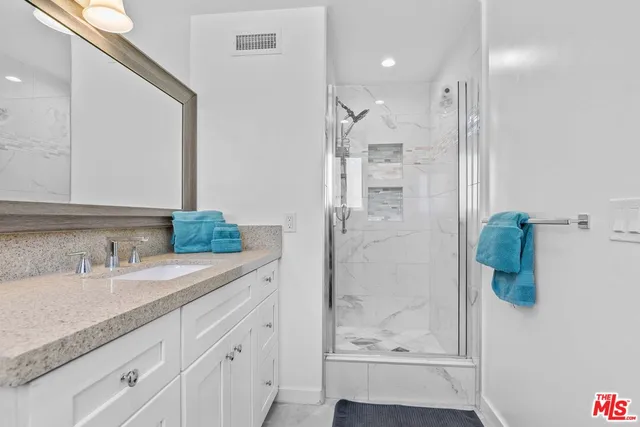a bathroom with a granite countertop sink and a mirror