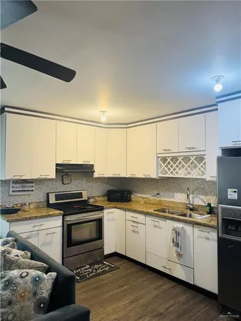 a kitchen with a sink white cabinets and white appliances