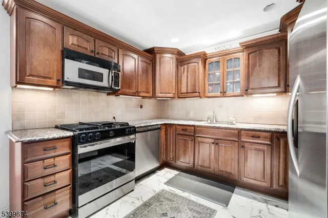 a kitchen with stainless steel appliances granite countertop a stove microwave and cabinets