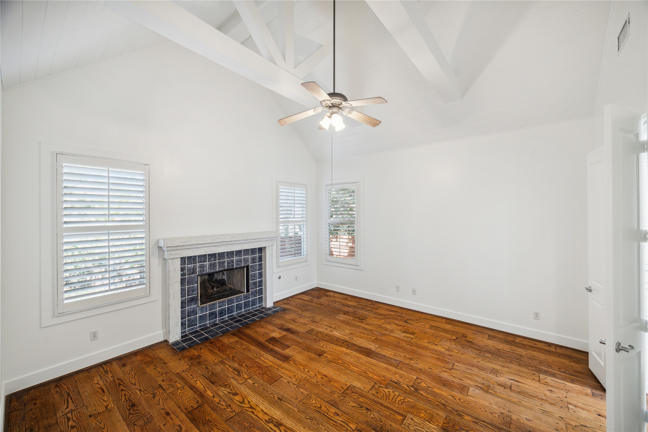 1238 West 22nd Street Houston, TX 77008 - Photo 14 of 43 Tight shot of the 1st floor Primary Bedroom (16x15) which features a private, tiled ceramic gas log fireplace and vaulted ceilings. The Primary bedroom is surrounded by trees.