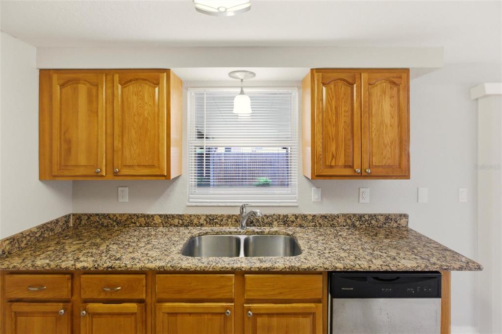 1107 Seneca Road Venice, FL 34293 - Photo 11 of 30 a kitchen with granite countertop cabinets sink and window