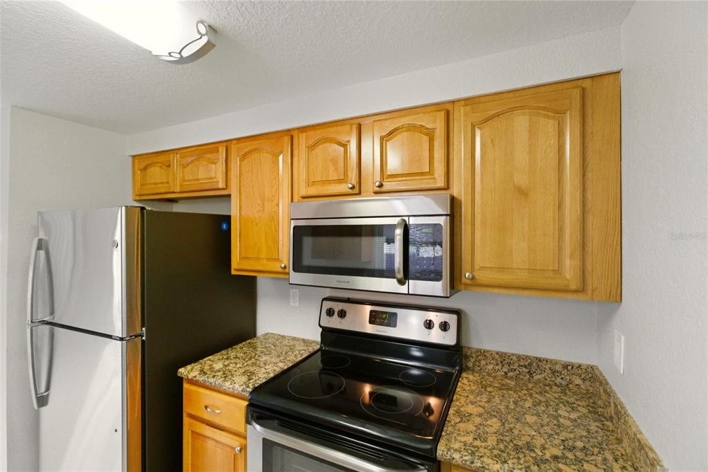 1107 Seneca Road Venice, FL 34293 - Photo 12 of 30 a kitchen with stainless steel appliances a stove a microwave and a refrigerator