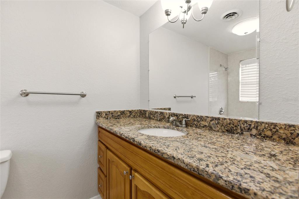 1107 Seneca Road Venice, FL 34293 - Photo 18 of 30 a bathroom with a granite countertop sink and a mirror