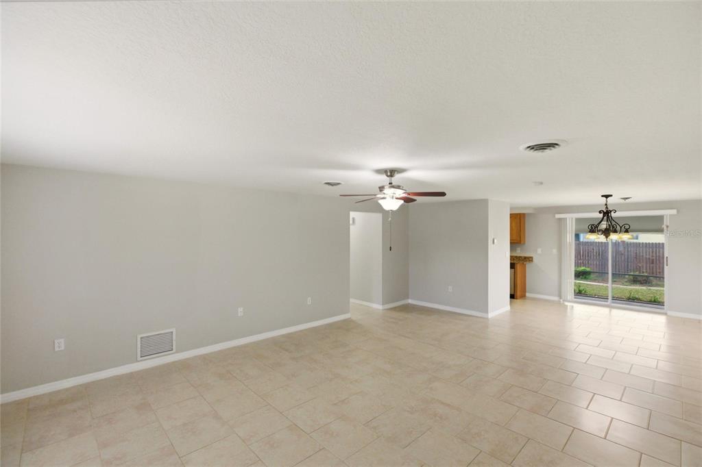 1107 Seneca Road Venice, FL 34293 - Photo 2 of 30 an empty room with chandelier fan and windows