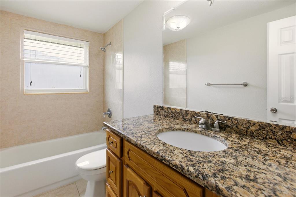 1107 Seneca Road Venice, FL 34293 - Photo 4 of 30 a bathroom with a granite countertop sink toilet and shower